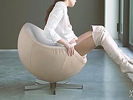 Slender Euro beauty in high boots fingers trimmed pussy while relaxing solo on unusual chair 4