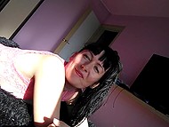 Pretty MILF with black hair and saggy boobies teases the unshaved vagina on her own 4