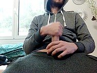 Bearded guy in hoodie shows how hands help him satisfy hard cock when he is alone 7