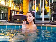 Busty girl with long pigtails swims naked in the pool and masturbates on the sun lounger 4