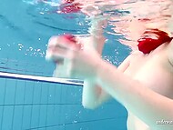 Redhead beauty takes off her sexy bikini and swims in the pool surrounded by young girlfriends 10